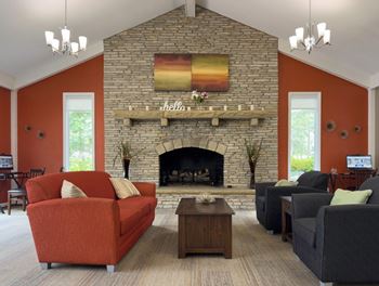 A living room with a fireplace and a painting above it.